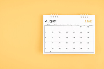 August 2025 desk calendar on yellow color background, position with copy space.