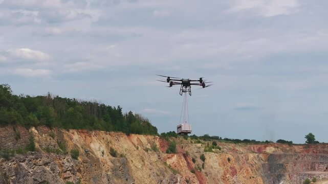Large transportation drone carry shipment box over limestone quarry, Czechia