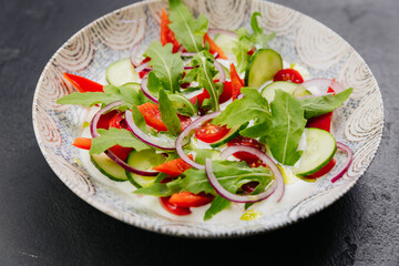 Colorful fresh salad with arugula, cucumbers, and tomatoes - a perfect dish for healthy eating 