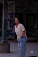 A woman looking at one side is waiting for a train to come in a dirty train station