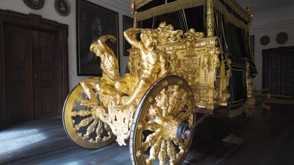 Golden carriage with intricate sculptures displayed inside Český Krumlov Castle, Czechia - Powered by Adobe