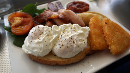 Big breakfast, poached eggs, hash browns, bacon, tomato, sausages