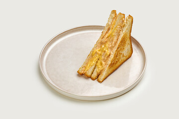 A classic grilled cheese sandwich with melted cheese and toasted bread. The sandwich is cut into triangles and served on a white plate.