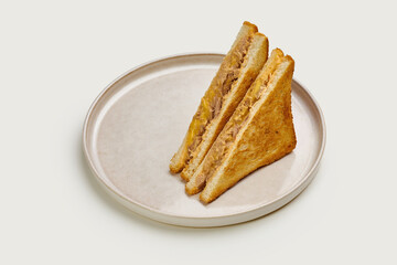 A classic grilled cheese sandwich with melted cheese and toasted bread. The sandwich is cut into triangles and served on a white plate.