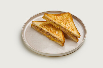 A classic grilled cheese sandwich with melted cheese and toasted bread. The sandwich is cut into triangles and served on a white plate.