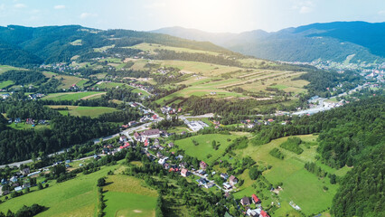 Fototapeta premium Rolling hills and valleys with green fields under soft sunset light