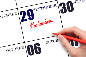 September 29. Hand writing text Michaelmas on calendar date. Save the date.
