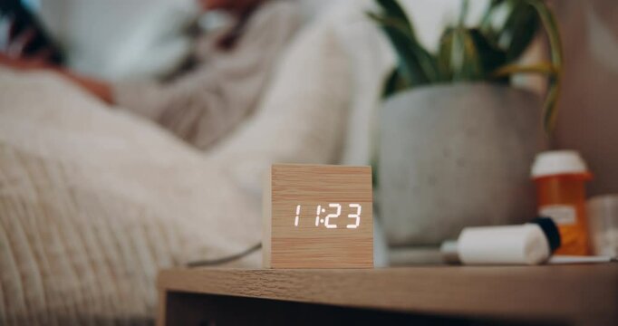 Alarm, night and time with person in bedroom of home for break, rest or sleep on weekend evening. Clock, digital and relax with bedside table in apartment for hospitality, peace or quiet in dark