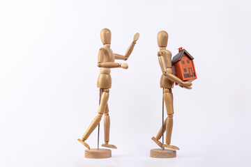 2 wooden figures representing an arguing couple and one of them taking a house, isolated on white...