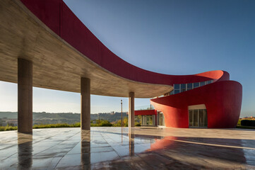 Red concrete renaissance house with curved lines.