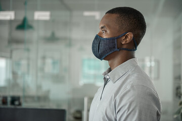 African businessman working in an office wearing a face mask