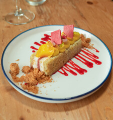 Un trozo de pastel con fruta en un plato blanco en un restaurante.