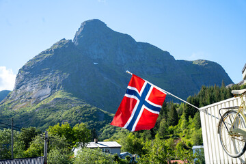 Norwegian flag against green mountain background
