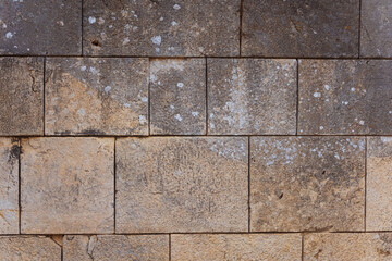 Texture of old stone wall with white paint stains and mold close-up
