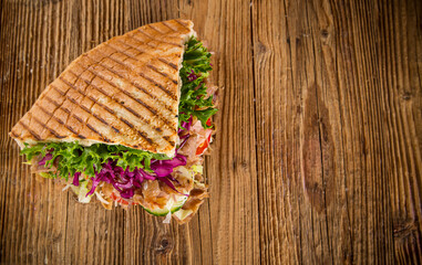 Doner Kebab Doner Kebap fast food snack in flatbread on a wooden table