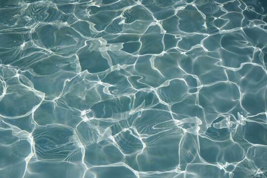 Ripple water surface and sun reflection for background. swimming pool.