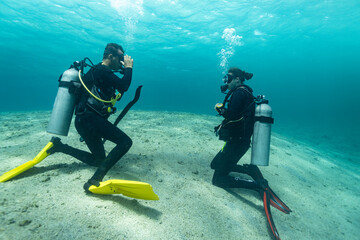 Diving instructor trains a novice who is learning to dive , underwater , Red sea .