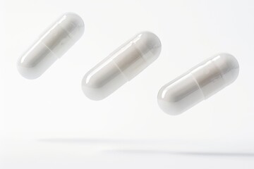 Three white pills suspended in mid-air, possibly from a drop or a burst