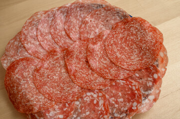 Okrągłe oryginalne włoskie salami w plastrach na talerzu
