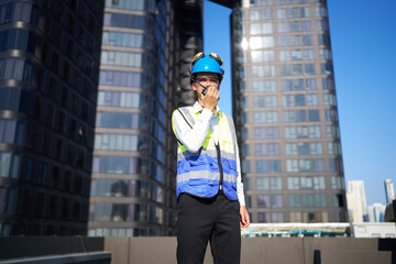 Engineer talking on walkie talkie at city on rooftop