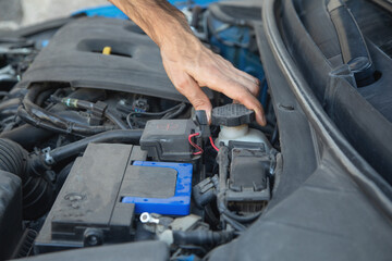 Man checking brake fluid in engine.