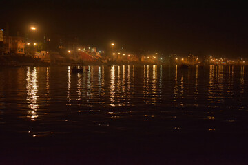 Night view of the Varanasi city reflection in river Ganga, Uttar pradesh, India