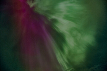 A purple and green aurora with a green and purple streak