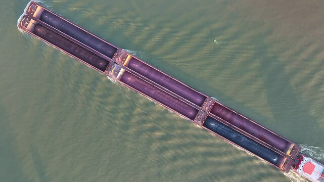 "Aerial view of a long cargo barge on a river