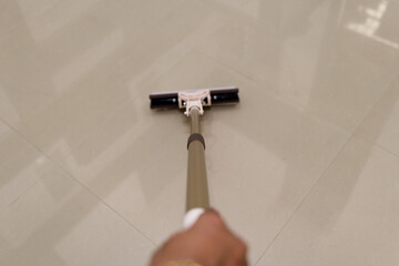 Hand Holding Mop Cleaning Smooth Tile Floor Surface