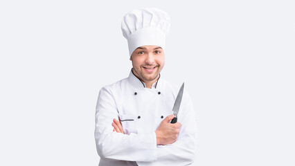 Positive Cook Man Holding Kitchen Knife Posing Standing Over White Background. Cooking Food Concept. Studio Shot