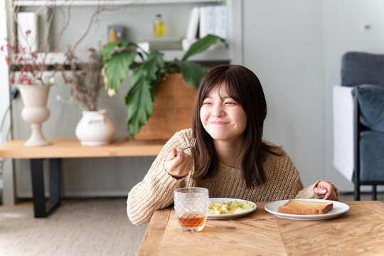朝ごはんを1人で食べている女性