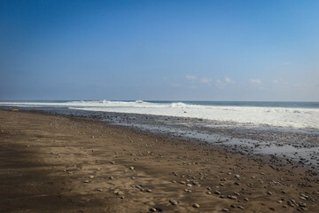A tranquil beach view at El Tunco, El Salvador with gentle waves and scenic coastline in the afternoon sunlight