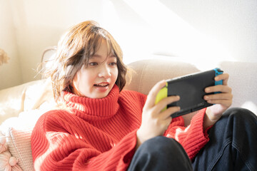 ソファでゲームを楽しんでいる女性