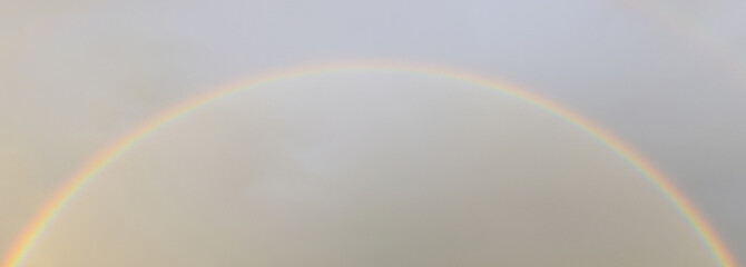 Rainbow against sunset sky. Natural background. Weather after rain.