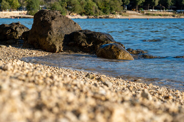 Pebble beach and rocks jutting into the sea on the Croatian Mediterranean coast. Close-up