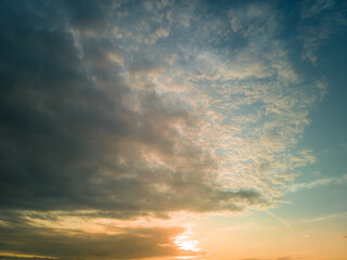 The rays of the sun breaking through the dramatic clouds in the evening or in the morning in the sunset or sunrise sky.