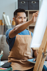 Male artist painting on canvas in the home studio, fine arts and creativity concept.