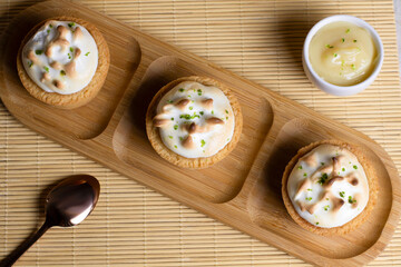 Baked lemon tarts with white meringue and lemon zest, delicious dessert