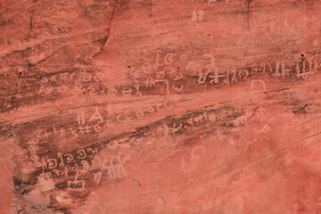 Ancient petroglyphs on a rocky surface in Wadi Rum Desert, Jordan showcasing historical art beneath...