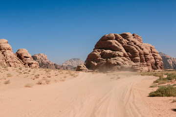 Exploring the stunning rock formations and sandy landscapes of Wadi Rum Desert in Jordan during bright daylight