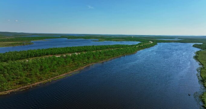 AERIAL: RV driving in middle of wetlands, summer in Kaldoaivi wilderness, Finland