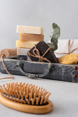 A beautifully arranged bathroom set featuring handmade soaps, a wooden hairbrush, and a loofah