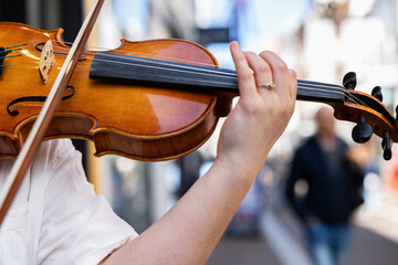 Young woman plays violin in the street of The Hague. Musician, talent, entertainment, teenager.