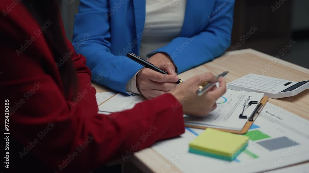 Poster two businesswomen discussing a financial report during a meeting create a collaborative environment 