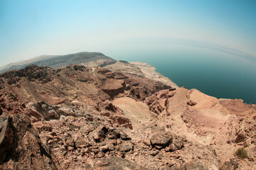 Expansive view of the rugged shoreline at the Dead Sea in Jordan highlighting unique geological features and the tranquil water below