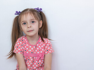 A thoughtful child. Portrait of a little girl with an innocent look on a white background. A place...