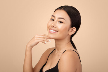 Facial Beauty Care. Portrait Of Happy Japanese Young Lady Touching Her Face And Chin Skin Over Gray...