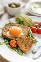 Fried bread and egg in toast with vegetables for breakfast, homemade healthy food on Valentine's Day