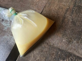 Evaporated milk or condensed milk in plastic isolated on wooden background. Good source of calcium....
