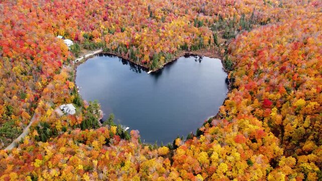 Aerial view of heart shape lake surrounded by autumn forest. Concept of earth day, love, environment, ecology. Baker Pond, Bolton-Est, Quebec, Canada.